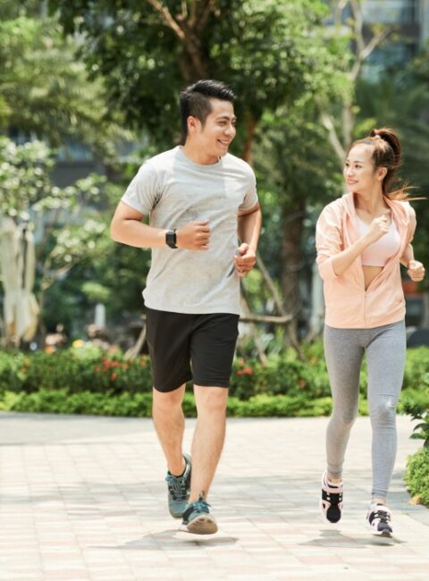 Vietnamese man and woman jogging together in the park