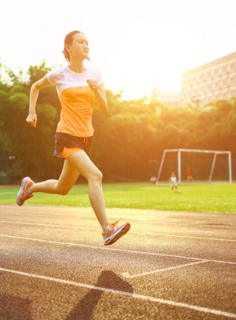Athletic woman running on track